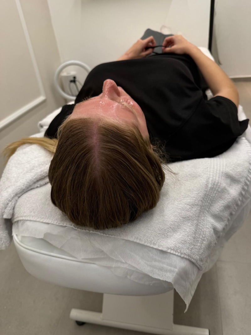Client during facial treatment session at clinic